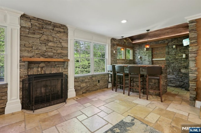 bar with a stone fireplace, recessed lighting, and stone tile flooring