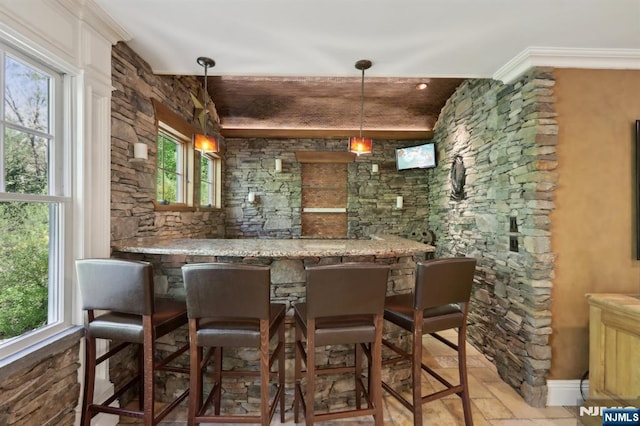 bar with decorative light fixtures, wet bar, plenty of natural light, and ornamental molding