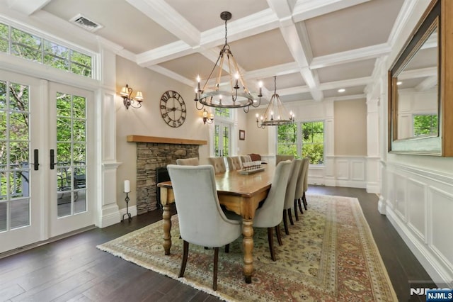 dining space with an inviting chandelier, plenty of natural light, a decorative wall, and visible vents