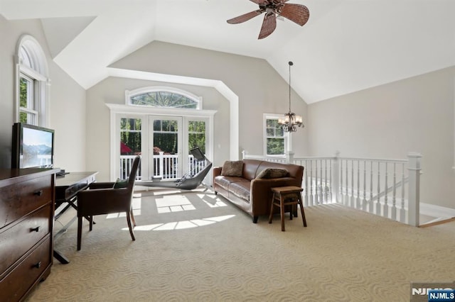 carpeted living area featuring ceiling fan with notable chandelier and lofted ceiling