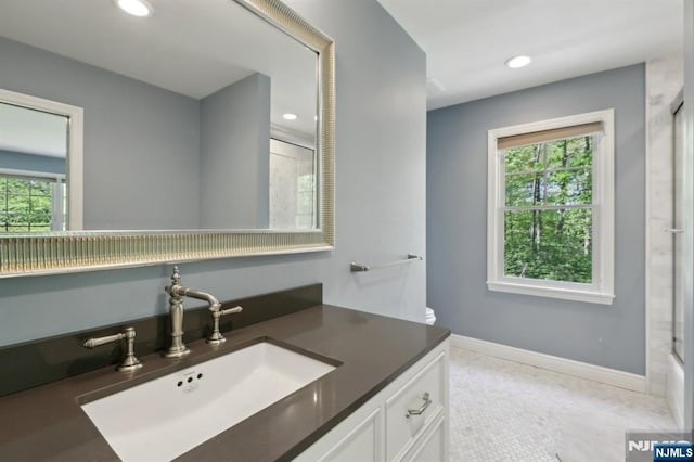 full bath featuring recessed lighting, baseboards, a healthy amount of sunlight, and vanity