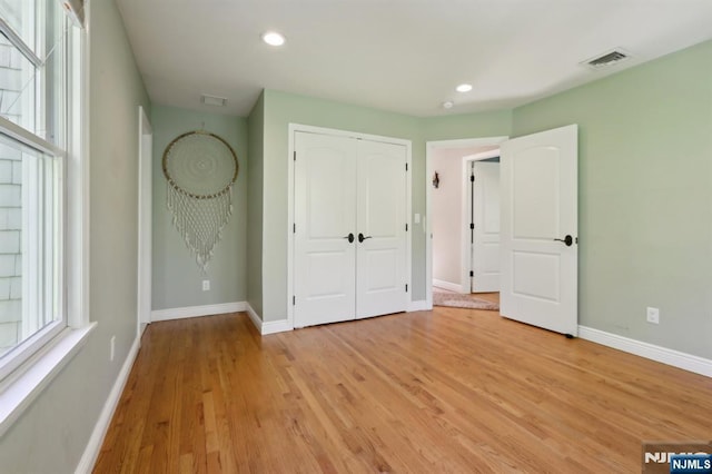 unfurnished bedroom with light wood-style floors, baseboards, recessed lighting, and visible vents
