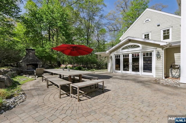 view of patio with outdoor dining area, exterior fireplace, and french doors