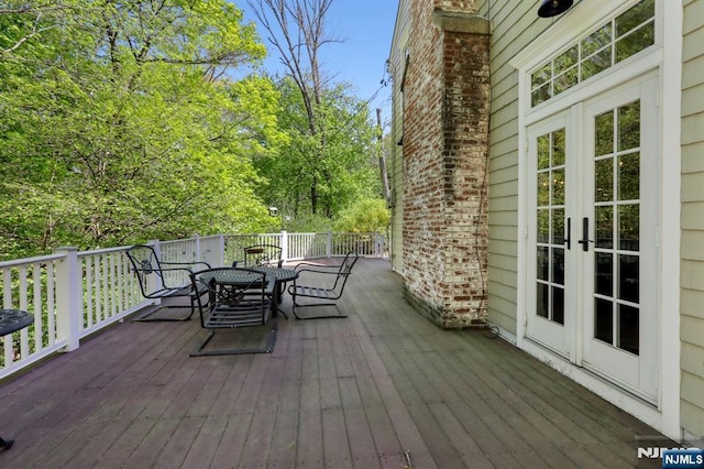 wooden deck featuring french doors and outdoor dining space