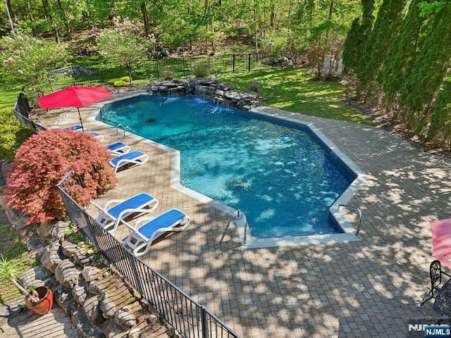 view of swimming pool featuring a fenced backyard, a fenced in pool, and a patio