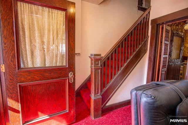 entrance foyer with stairway and baseboards