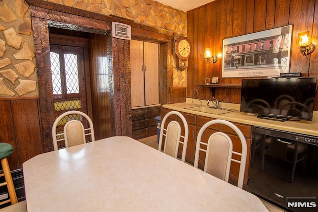 dining space with indoor wet bar, wooden walls, and beverage cooler