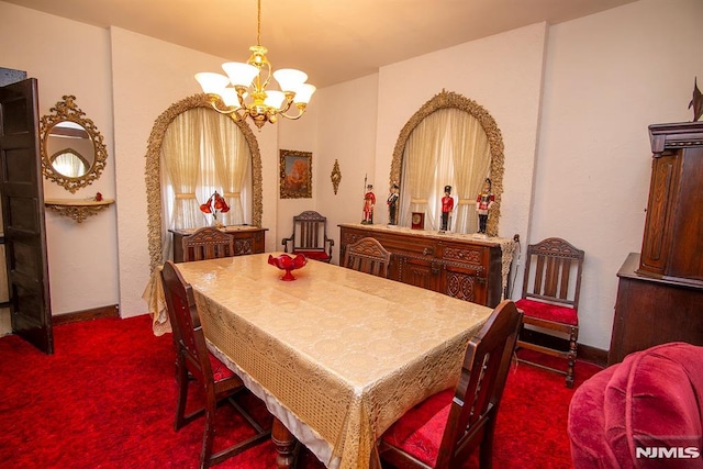 dining area featuring baseboards, a chandelier, and dark carpet