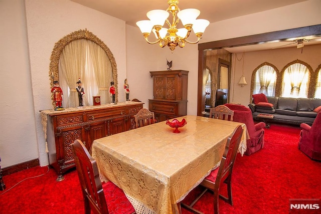 dining space with a chandelier, baseboards, and dark colored carpet