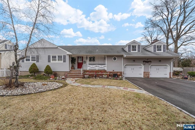 view of front of home featuring fence, aphalt driveway, a porch, a front yard, and a garage