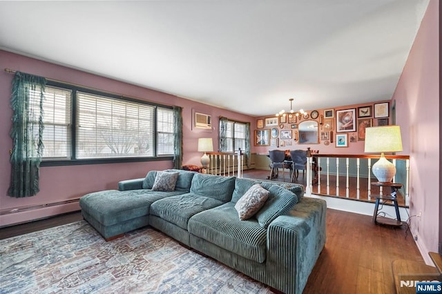 living area featuring a notable chandelier, a baseboard heating unit, baseboards, and wood finished floors