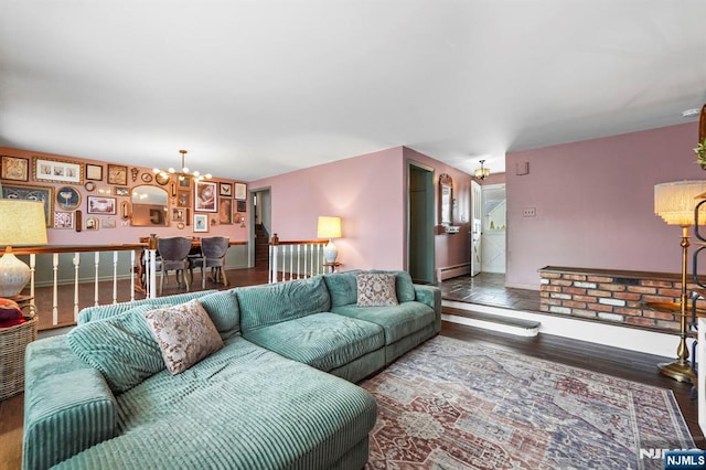 living room with a baseboard radiator, baseboards, an inviting chandelier, and wood finished floors