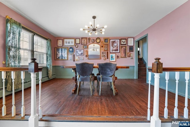 dining room featuring a notable chandelier, stairs, baseboards, and wood finished floors