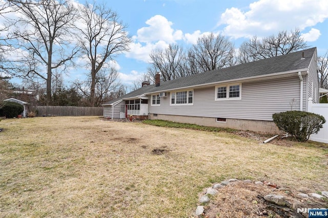 view of front of home with a chimney, a front yard, and fence