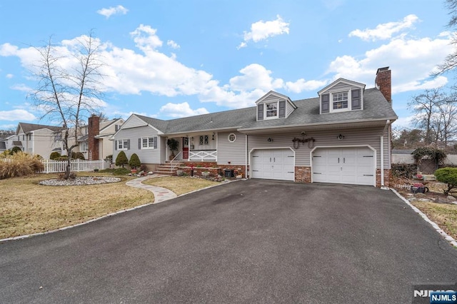 view of front of house with fence, a front yard, a chimney, a garage, and driveway