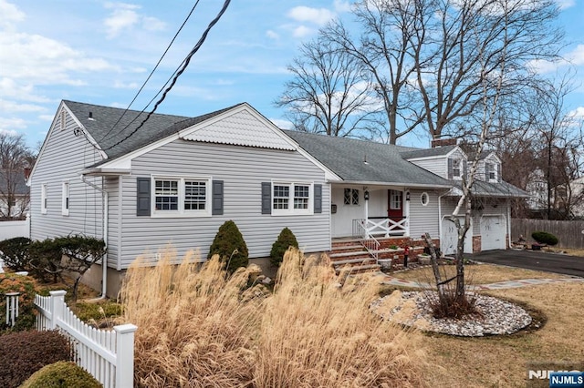 view of front of property featuring driveway, a porch, fence, roof with shingles, and a garage