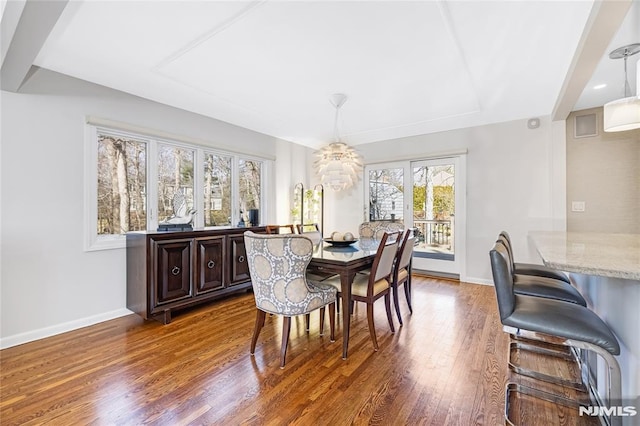 dining space with baseboards and wood finished floors