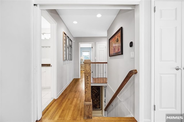 corridor featuring recessed lighting, an upstairs landing, baseboards, and light wood finished floors