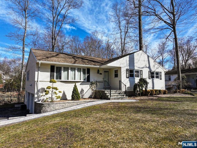 view of front of home featuring brick siding, a garage, and a front lawn