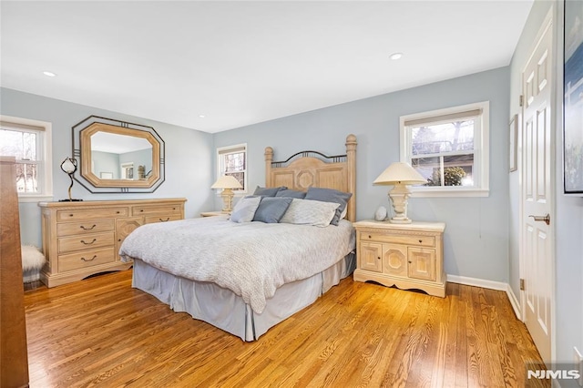 bedroom with light wood-style flooring and multiple windows