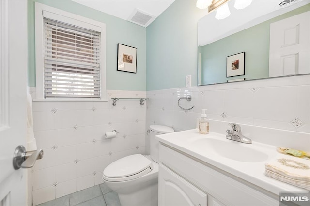 bathroom with visible vents, toilet, vanity, and tile patterned flooring