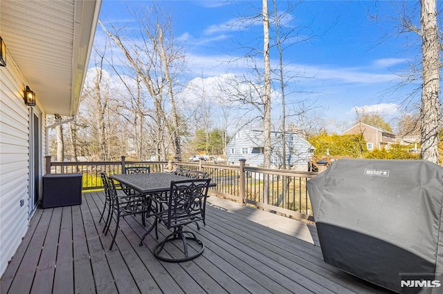 wooden deck featuring grilling area and outdoor dining area