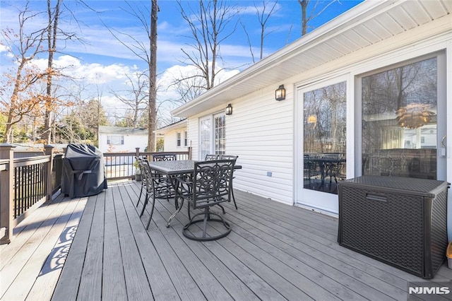 wooden deck with grilling area and outdoor dining space