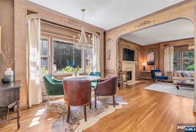 28 Scott Ct, Allendale, NJ 07401 - dining area with a chandelier, a warm lit fireplace, wood finished floors, crown molding, and arched walkways