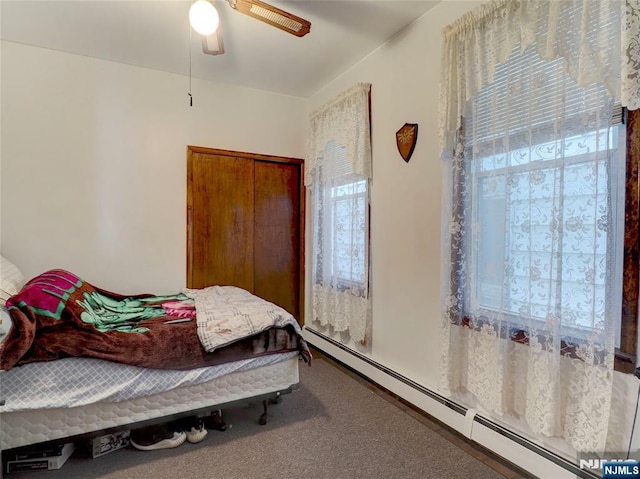 carpeted bedroom featuring a ceiling fan and baseboard heating