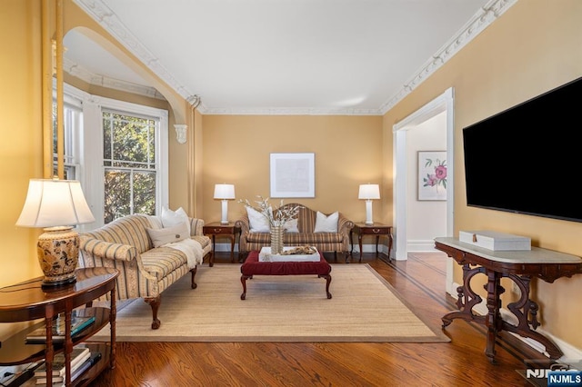 living room with baseboards, wood finished floors, and crown molding