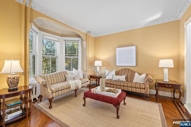 living room with crown molding, wood finished floors, and baseboards