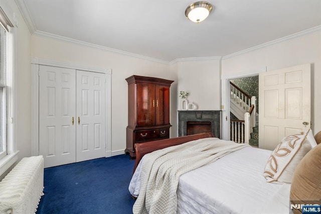 bedroom with ornamental molding, radiator heating unit, a closet, a fireplace, and dark colored carpet