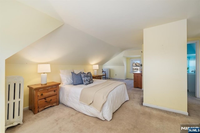 bedroom featuring light colored carpet, radiator, baseboards, and lofted ceiling