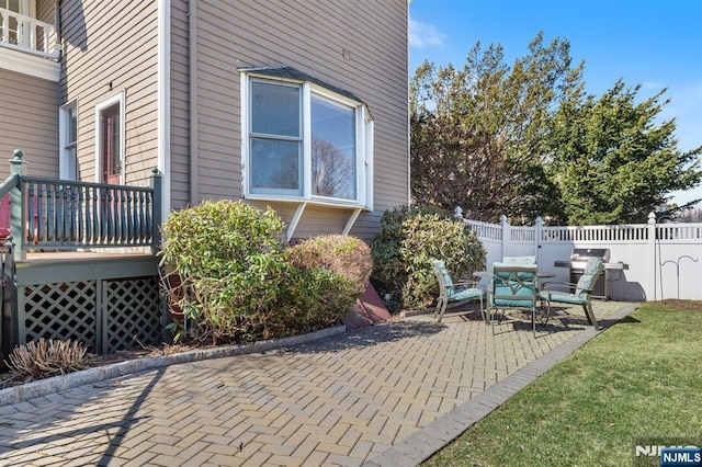 view of patio featuring a wooden deck and fence