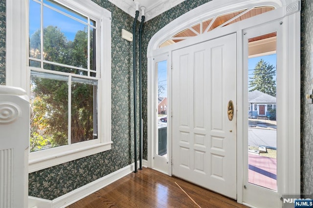 entryway featuring wallpapered walls, dark wood-style floors, and baseboards