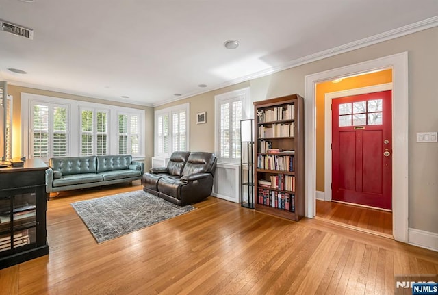 living room with visible vents, plenty of natural light, hardwood / wood-style floors, and ornamental molding