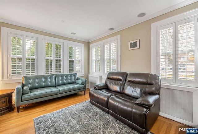 living room with plenty of natural light, wood finished floors, and crown molding