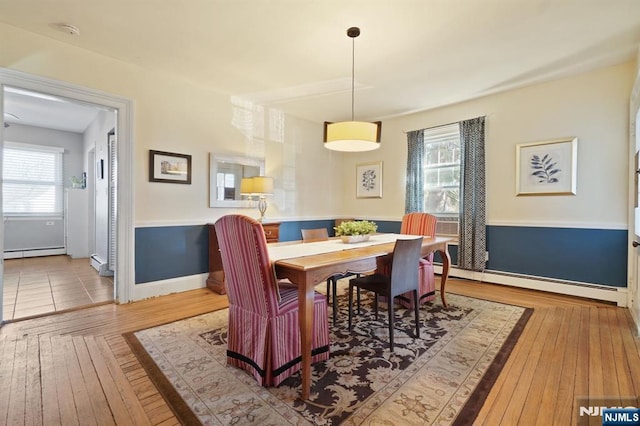 dining space featuring hardwood / wood-style floors, baseboards, and a baseboard radiator