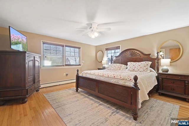 bedroom featuring a ceiling fan, light wood-style floors, and a baseboard radiator