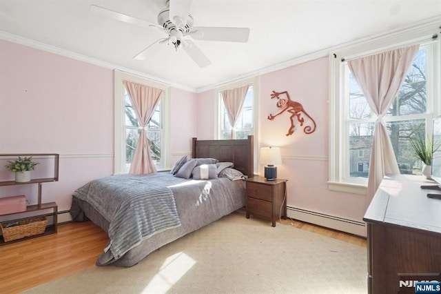 bedroom with light wood-type flooring, a baseboard radiator, ceiling fan, and crown molding