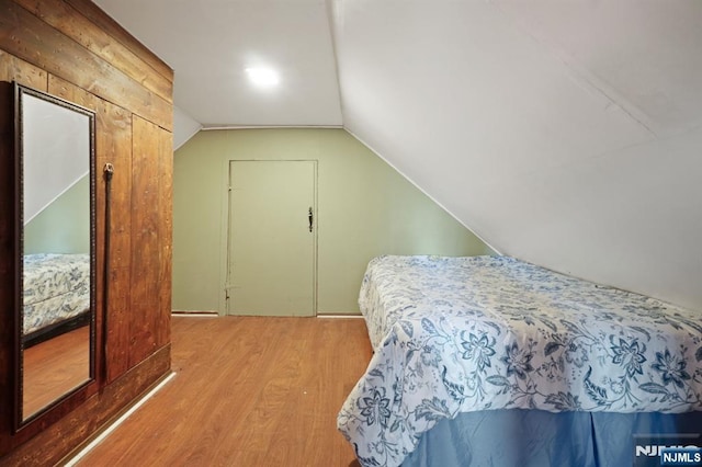 bedroom with lofted ceiling and wood finished floors