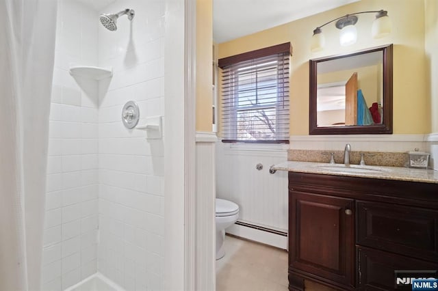 full bathroom featuring a wainscoted wall, tiled shower, and a baseboard heating unit