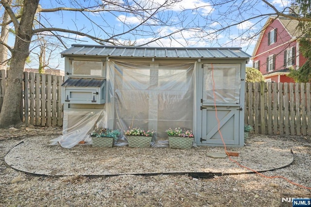 view of greenhouse with a fenced backyard