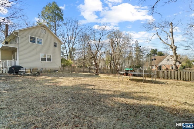 view of yard with a fenced backyard, a patio, and a trampoline