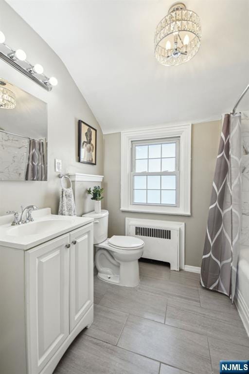 bathroom featuring radiator, toilet, vaulted ceiling, a notable chandelier, and vanity