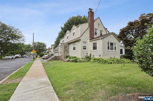 view of property exterior featuring a chimney and a yard