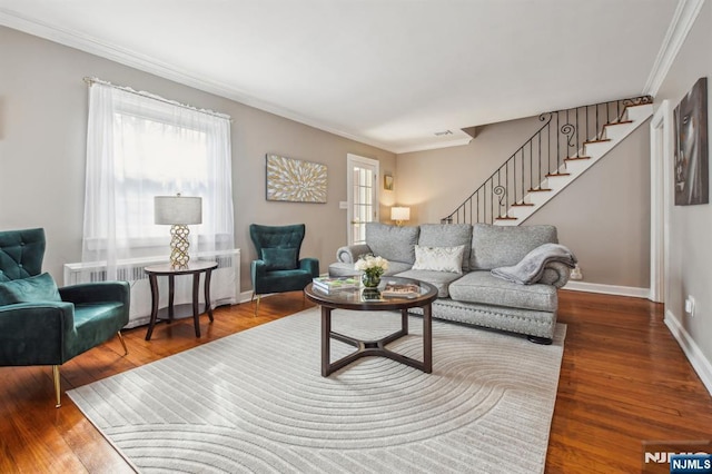 living room featuring radiator, wood finished floors, and a wealth of natural light