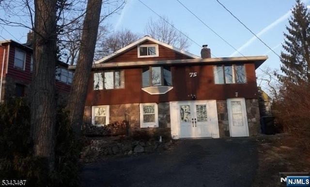 view of front of home featuring driveway and a chimney