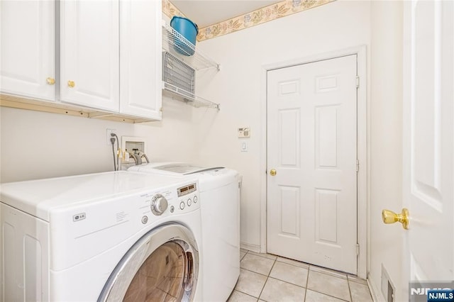 clothes washing area featuring light tile patterned floors, visible vents, washing machine and dryer, and cabinet space