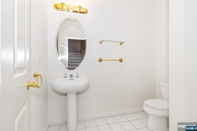 bathroom featuring tile patterned flooring, toilet, and baseboards